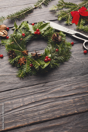 Handmde christmas wreath decoration on rustic wood background, vertical