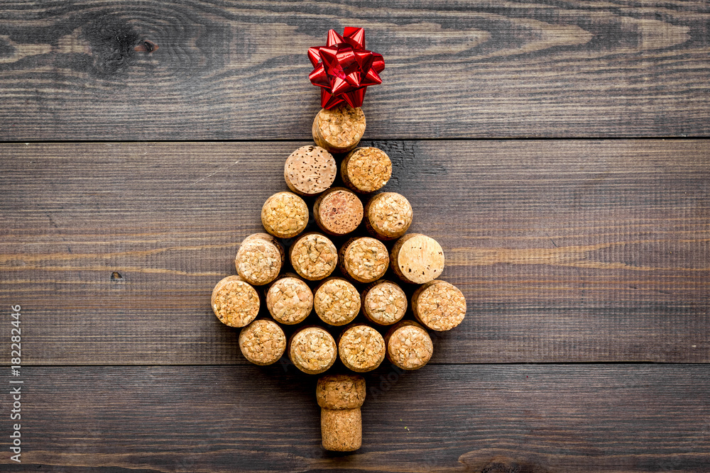 Corks of wine bottles in shape of new year spruce on dark wooden background top view copyspace Corks of wine bottles in shape of new year spruce on dark wooden background top view copyspace