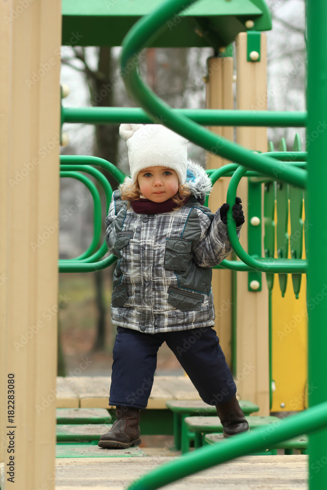 Two year old girl surmounting obstacle course on the winter playground Two year old girl surmounting obstacle course on the winter playground