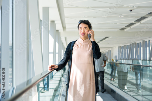 Photography Girl using phone while on the travelator inside