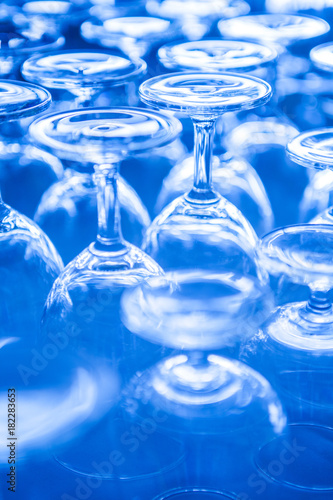 Group of empty wine glass upside down in row blue tone