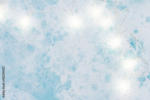Christmas bright lights on light blue background with copy space