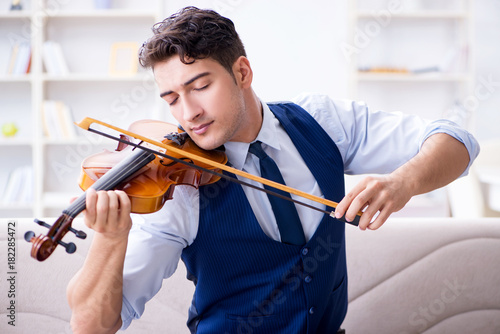Photo Young musician man practicing playing violin at home