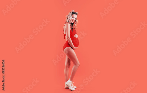 pregnant girl in red body and white sneakers