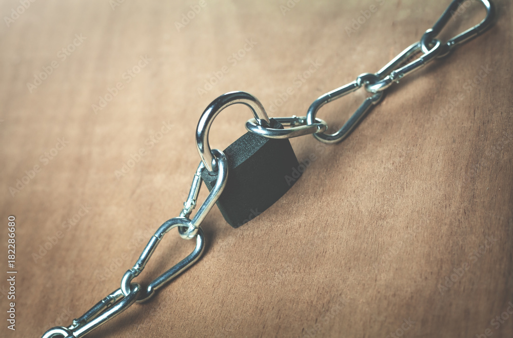Padlock and chains on a wood background. Padlock and chains on a wood background.