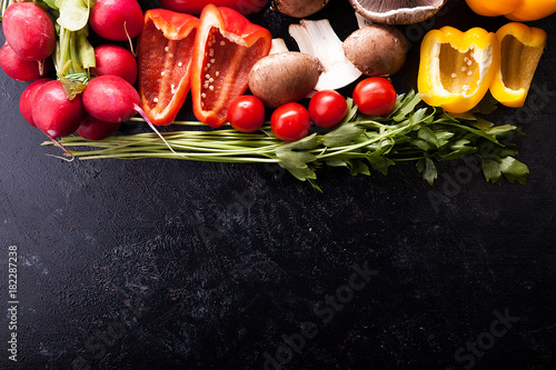 Different type of organic healthy vegetables on dark wooden background. Copy space available for text