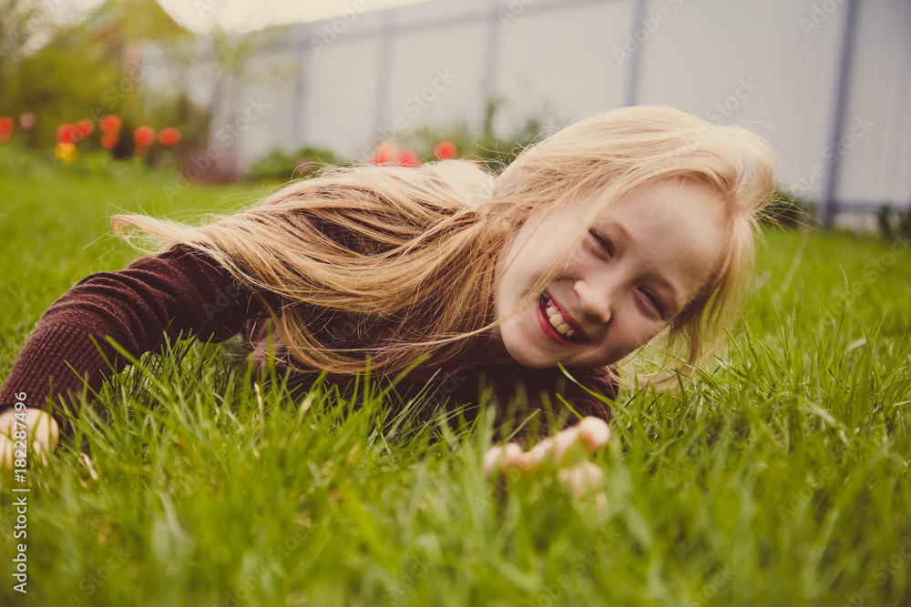 Girl lying on green grass laughing and smiling Girl lying on green grass laughing and smiling