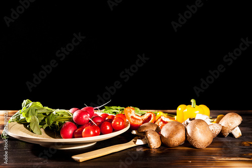 Fototapeta Naklejka Na Ścianę i Meble -  Organic healthy food. Vedetables on burned wooden background. Artistic lighting