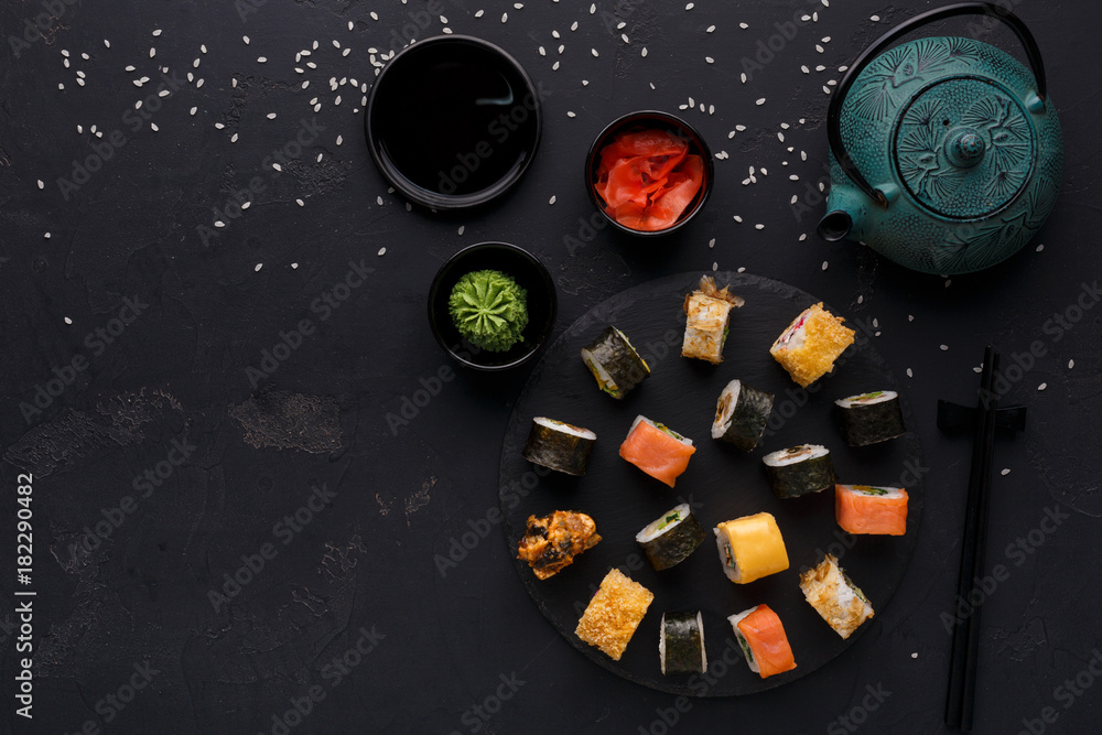 Set of sushi maki and rolls on black background Set of sushi maki and rolls on black background