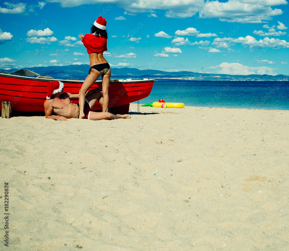 Christmas couple in red at beach boat. Christmas couple in red at beach boat.