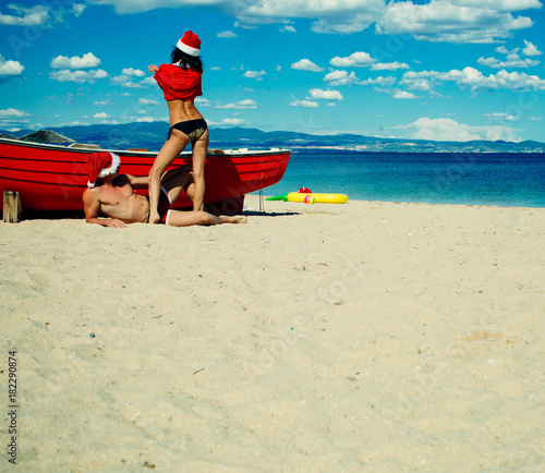 Christmas couple in red at beach boat.