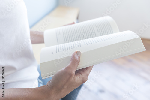 Closeup of a reader reading a book at home