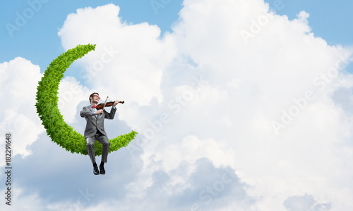 Εκτύπωση καμβά Handsome violinist on moon in blue sky play his melody