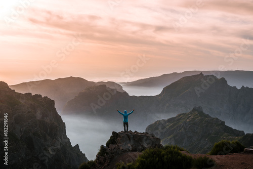 Adult male hiker celebrating the sunset over the mountain panorama of Madeira, Portugal photo