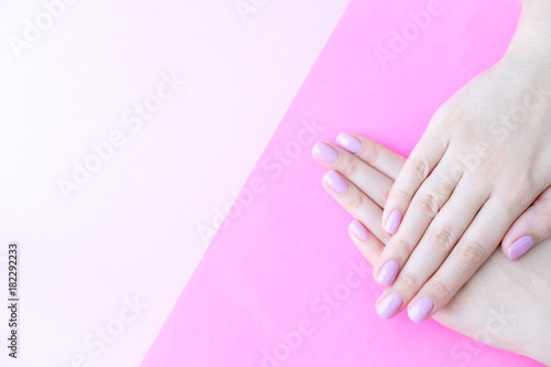 Close up pink nails for girls. Stylish trendy female manicured fingernails. Beautiful young woman's hands on pink and blue background. Top view, flat lay. copy space for text