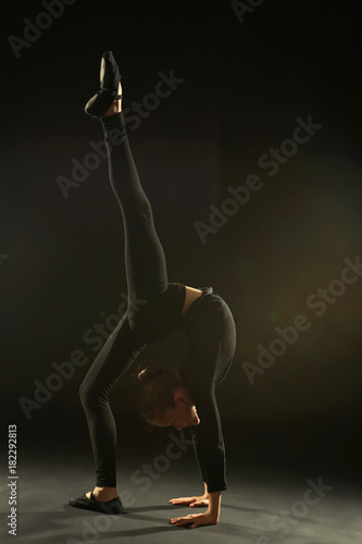 Young girl gymnast on black background