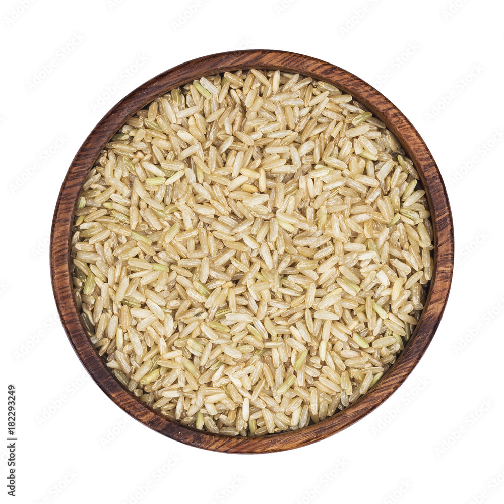 Brown rice groats in wooden bowl isolated on white background. Top view Brown rice groats in wooden bowl isolated on white background. Top view