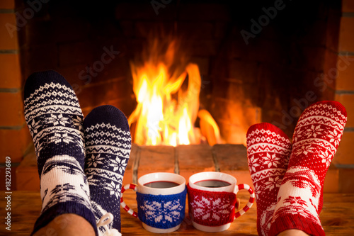 Couple in Christmas socks near fireplace photo