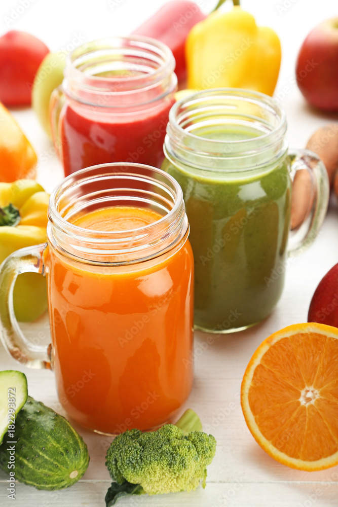 Vegetables smoothie in jars on white wooden table Vegetables smoothie in jars on white wooden table