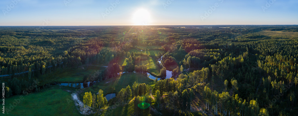 Fototapeta premium Aerial View. Flying over the beautiful summer rivers at sunset.