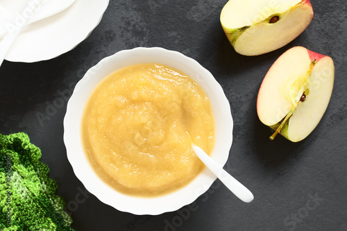 Foto Fresh homemade apple sauce in bowl, photographed overhead on slate with natural