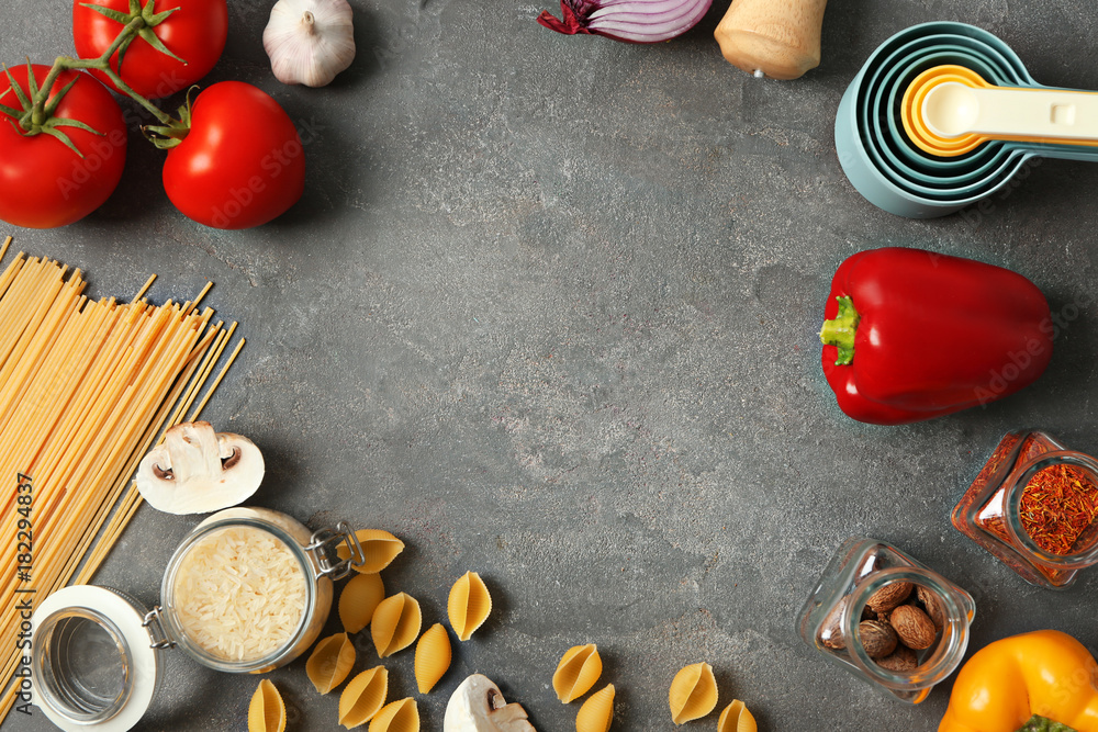 Kitchen utensils and food ingredients on grey background Kitchen utensils and food ingredients on grey background