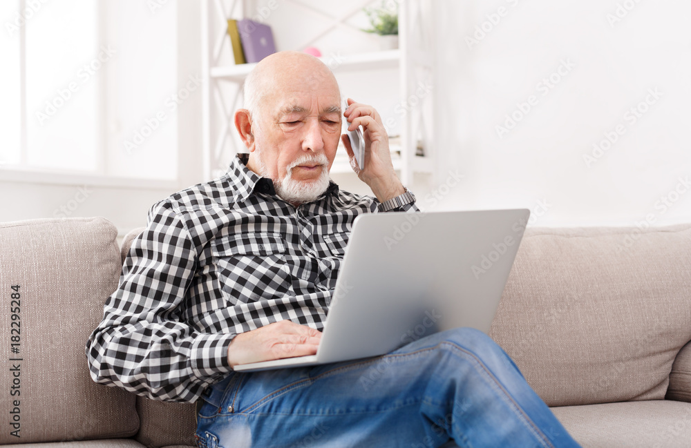 Senior man talking on phone with laptop Senior man talking on phone with laptop