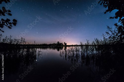 Fototapeta Naklejka Na Ścianę i Meble -  Stars over the lake at summer night on dark sky. Starfall. Milky way.