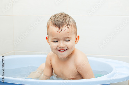 Happy baby boy taking a bath