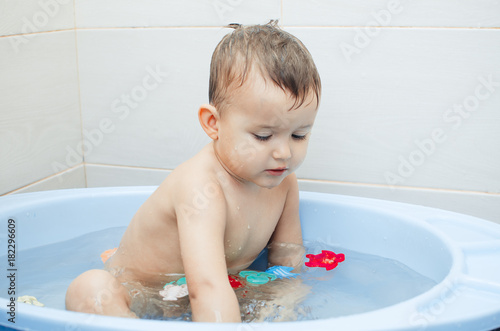 Happy baby boy taking a bath