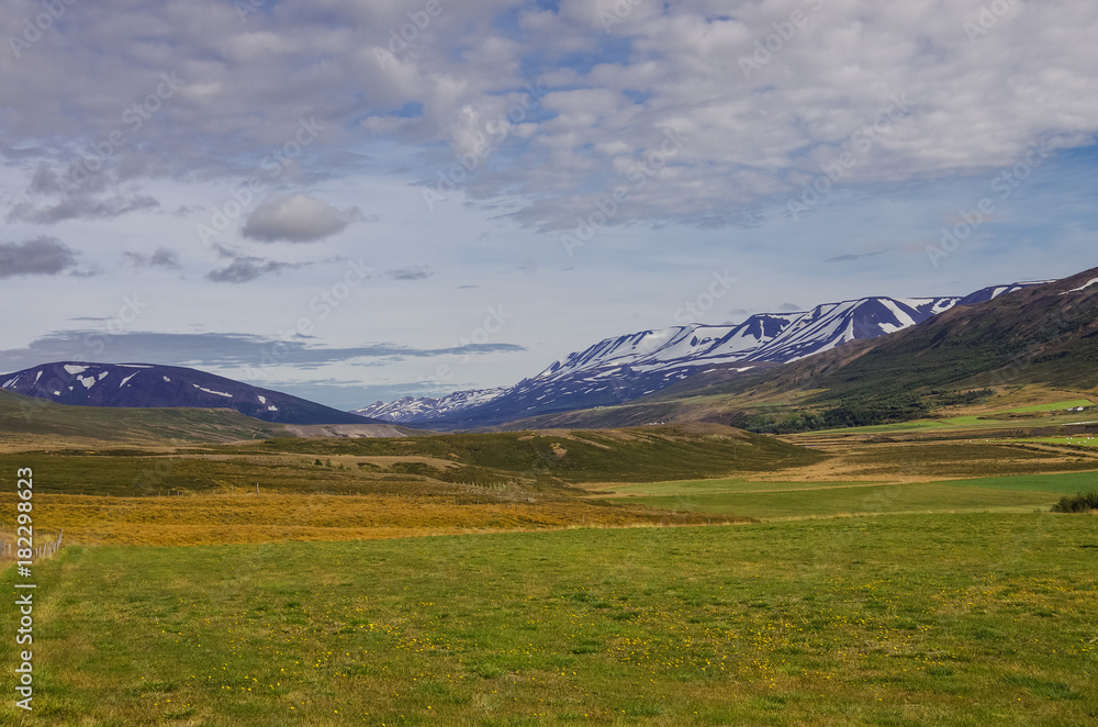 Panorama valley of snow covered mountains. Beautiful summer landscape near ringroad from Akureyri,Iceland.