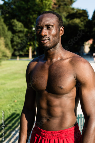 Athletic black man posing in a city park
