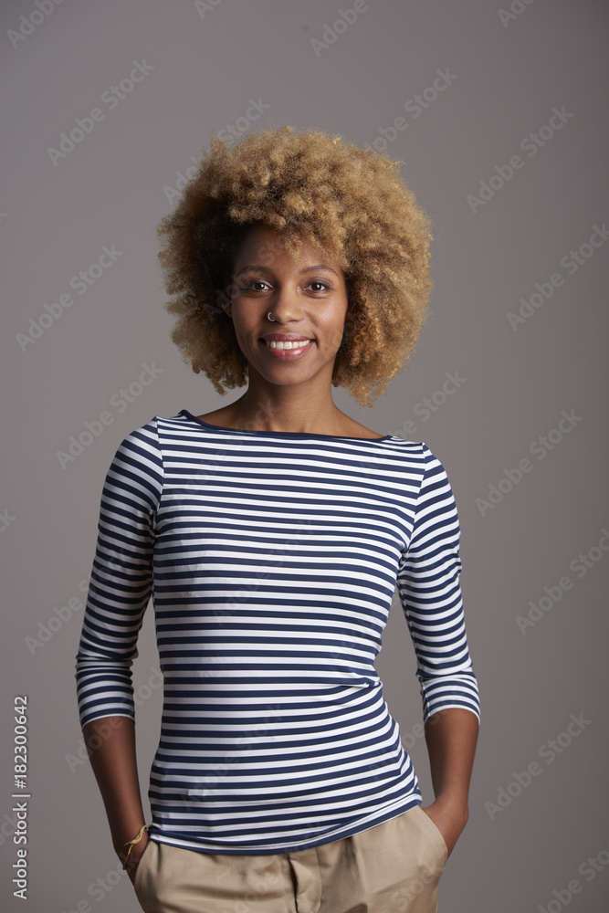 Studio portrait of a beautiful happy afro-american ethnicity woman standing against at isolated gray background while looking at camera and smiling. Studio portrait of a beautiful happy afro-american ethnicity woman standing against at isolated gray background while looking at camera and smiling.