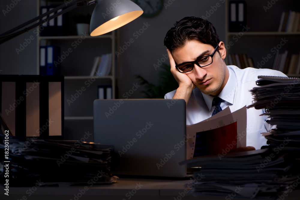 Young businessman working overtime late in office Young businessman working overtime late in office