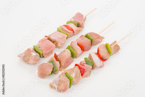 skewers of raw meat and vegetables