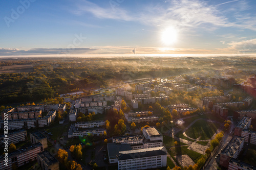 Aerial view of beautiful sunrise over the city. City in fog, misty landscape. © nikwaller
