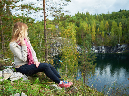 Young woman with long blonde hair enjoying beautiful lake view at a canyon.