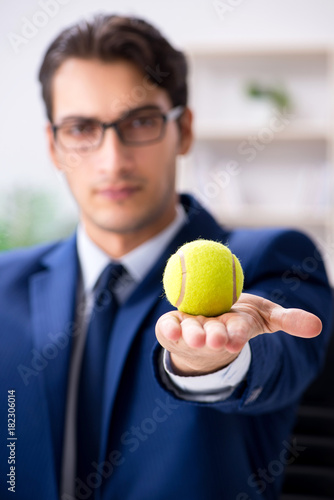 Young businessman with tennis ball working in office © Elnur