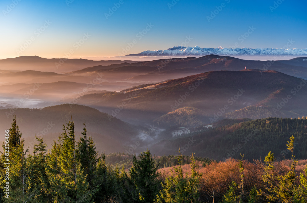 Naklejka premium panorama over misty Gorce to snowy Tatra mountains in the morning, Poland landscape