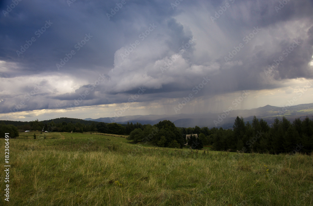The grassy plain landscape with dramatic scenic sky with rain strands