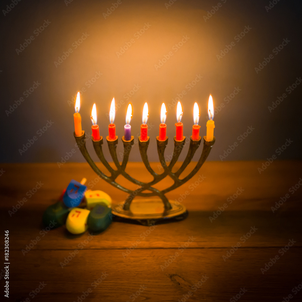 Fototapeta premium Hanukkah menorah with candles and wooden dreidels.