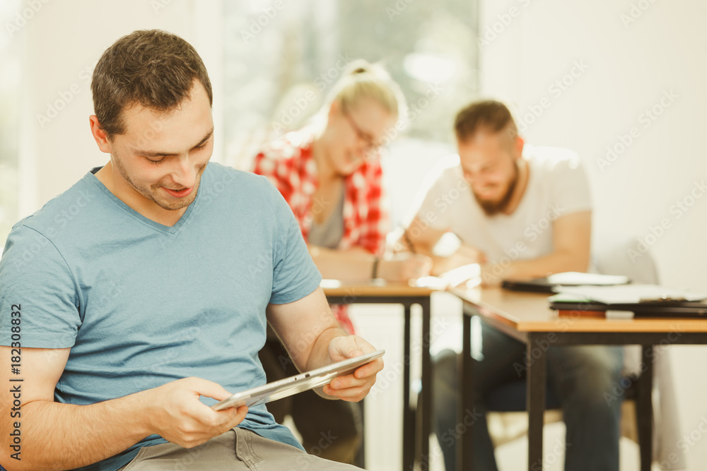 Student boy with tablet in front of her classmates