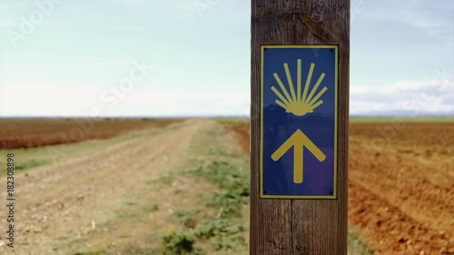 The typical pilgrim sign on the Camino de Santiago: the yellow arrow and the yellow shell. photo