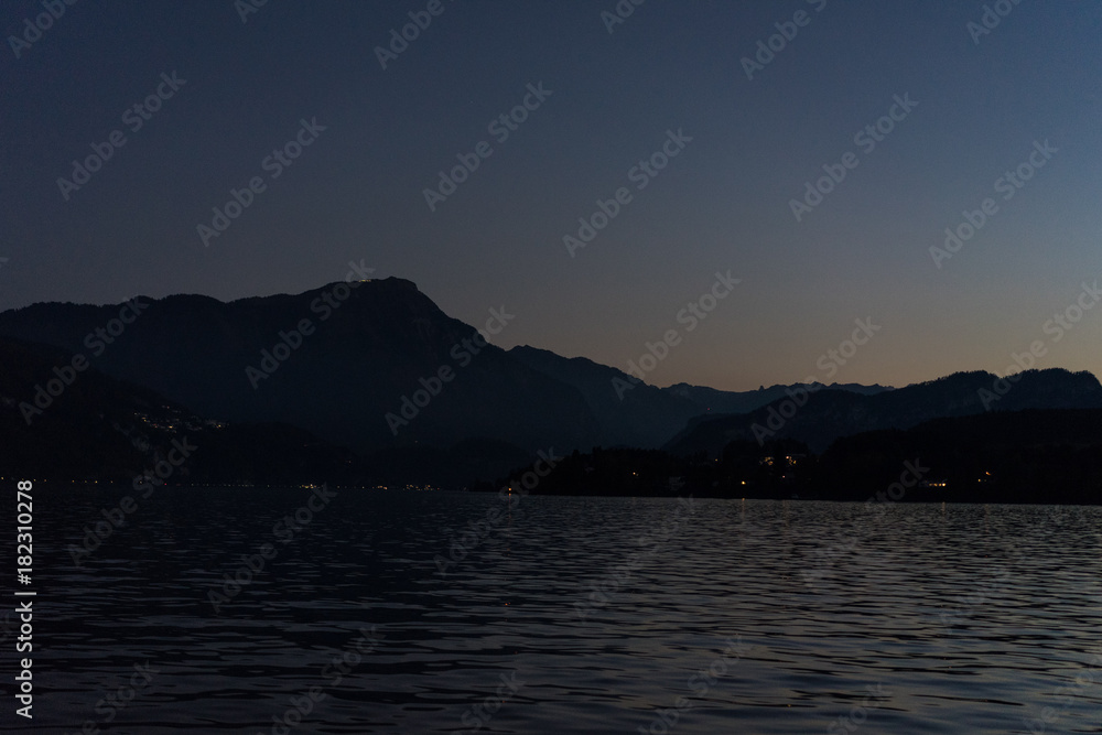 sunset at lake lucerne with mountains viewed from boat