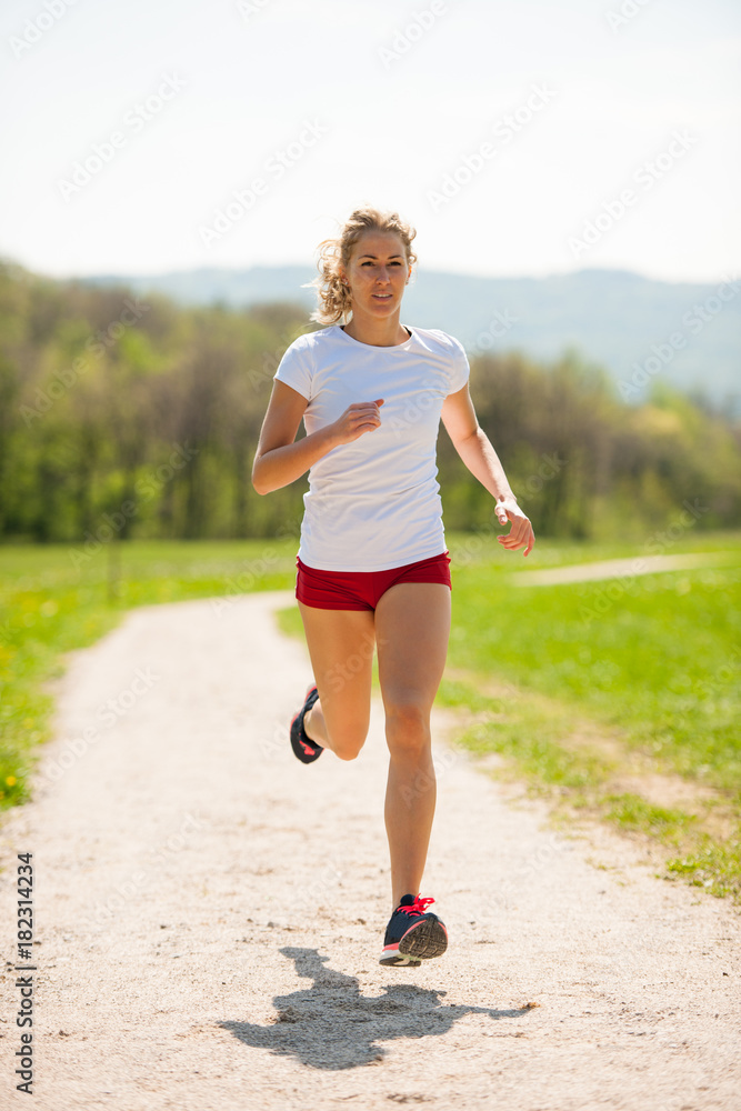 Woman runner runs - workout in spring Woman runner runs - workout in spring