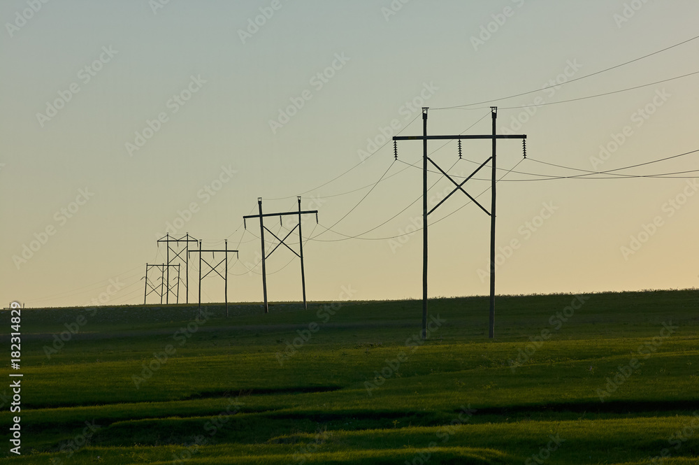 Rural scene with electricity pylons at sunset