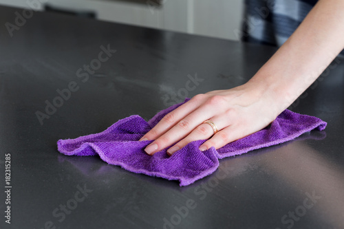 hand of a woman cleaning a tablewith a cloth