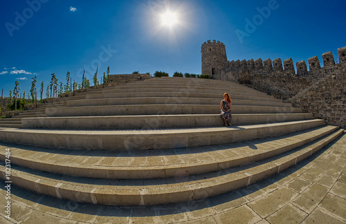 Young woman tourist sitting on a large staircase in Rabati Castle photo