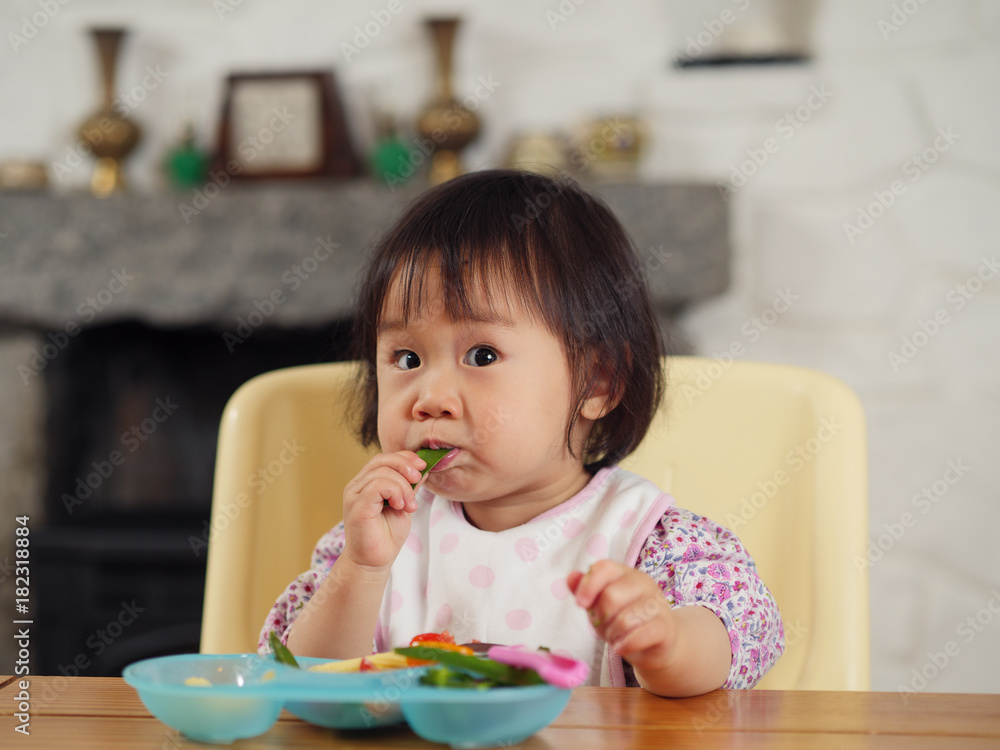 baby girl eating vegetable at home baby girl eating vegetable at home