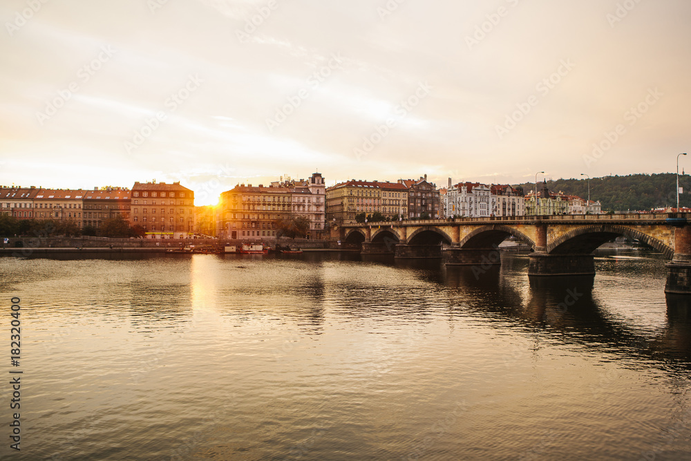 Beautiful view of the architecture of Prague in the Czech Republic at sunset. Traditional houses and a bridge across the Vltava River.